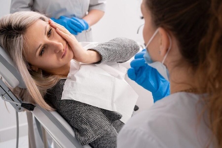 A girl having tooth pain and looking for professional 24-hour emergency dentists near her.