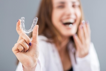 woman holding invisalign braces