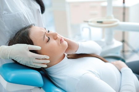 A female patient having wisdom tooth pain and requiring oral and maxillofacial surgery.
